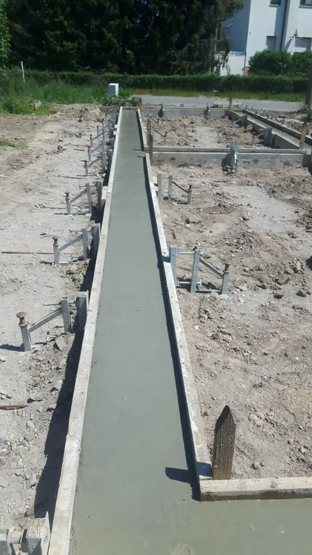 Frisch gegossene Streifenfundamente auf einer Baustelle