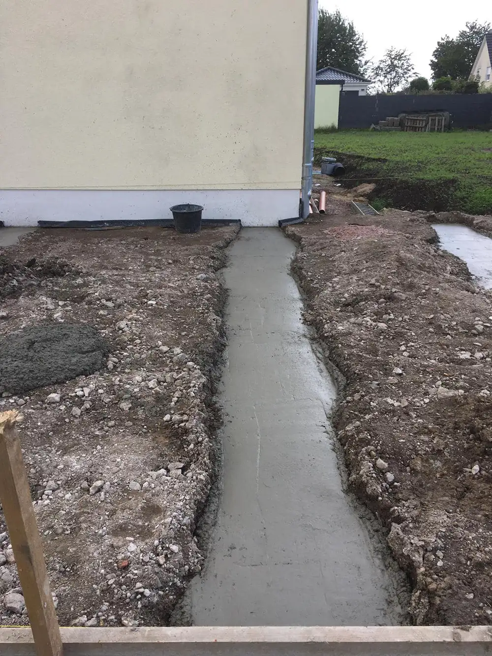 Frisch gegossene Streifenfundamente an einem Haus